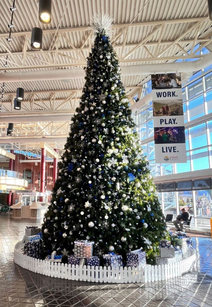 ROA Holiday Tree 2024 adorned in silver, white, and blue ornaments and gifts