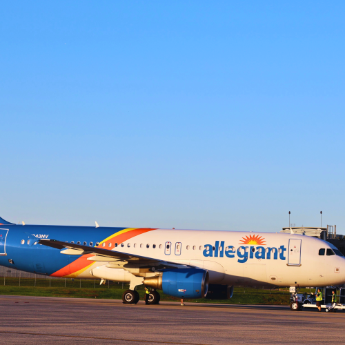 Allegiant plane parked at ROA gate on a blue sky day