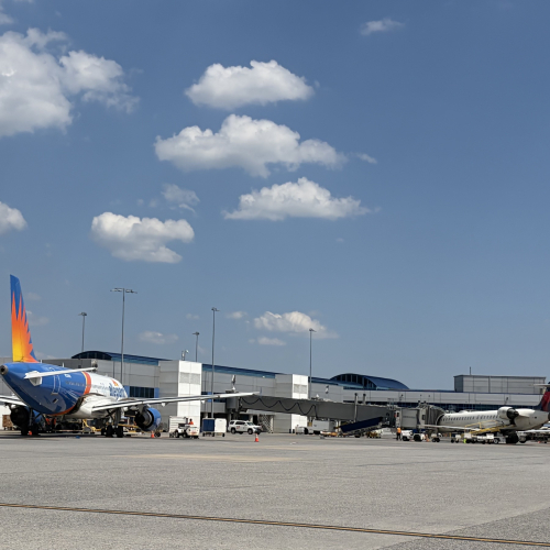 Allegiant and Delta planes parked at ROA concourse - view is from the airfield