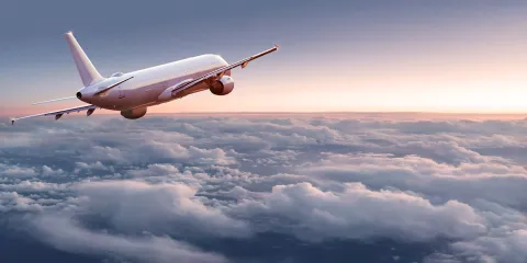 A large airplane flying above the clouds