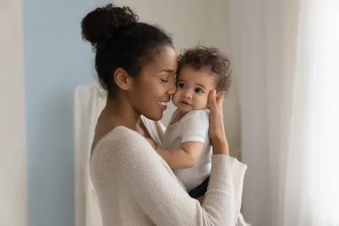 A woman holding a young child close to her