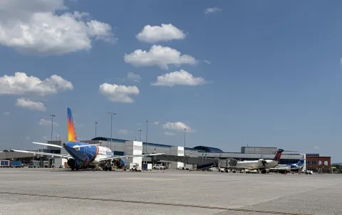Allegiant and Delta planes parked at ROA concourse - view is from the airfield