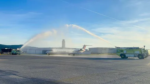 PSA Aircraft taxiing under ARFF water canon salute for DFW inaugural flight